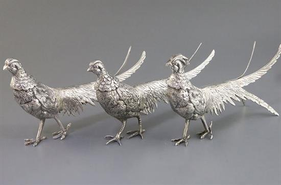 A suite of 3 Egyptian white metal free standing model pheasants, comprising a cock and two hens, cock 28cm.